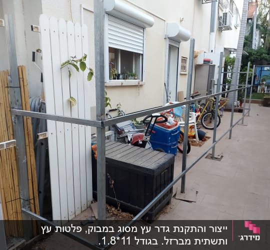 מסגרת מתכת ליד גדר עץ לבנה בגינה